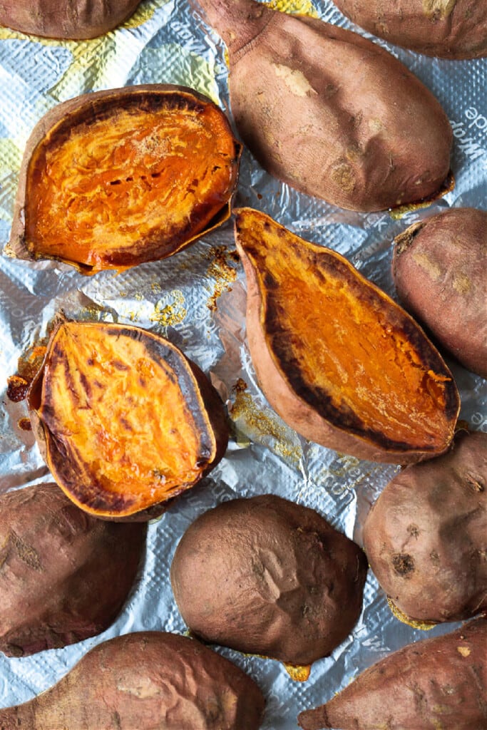 Our Sweet Potato Souffle is light and fluffy with a sweet, nutty streusel topping! A make ahead side dish for all of your holiday dinners! roasted sweet potatoes on baking sheet