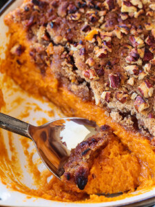 spoon in baking dish with sweet potato souffle