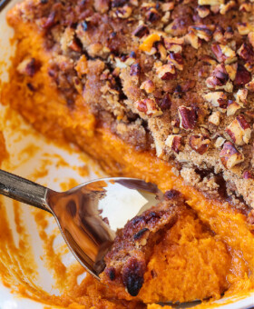 spoon in baking dish with sweet potato souffle