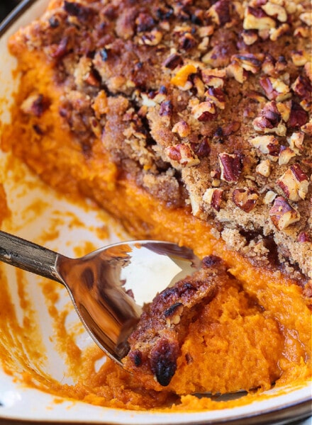 spoon in baking dish with sweet potato souffle