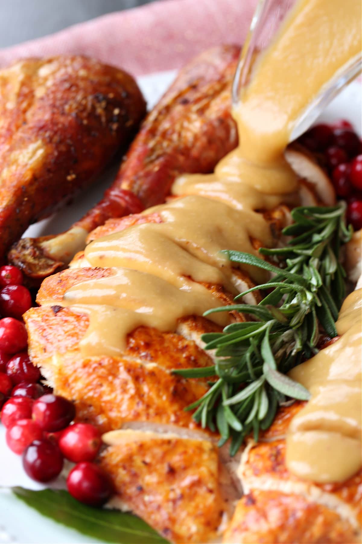 This homemade turkey gravy from drippings only takes minutes to make! A creamy, thick, delicious gravy recipe for your entire turkey dinner! turkey gravy being poured onto sliced turkey