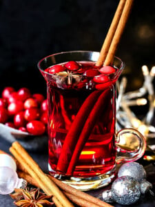 christmas punch in glass mug with cinnamon stick garnish