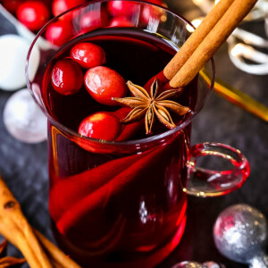 red punch in glass mug with cranberries and cinnamon stick