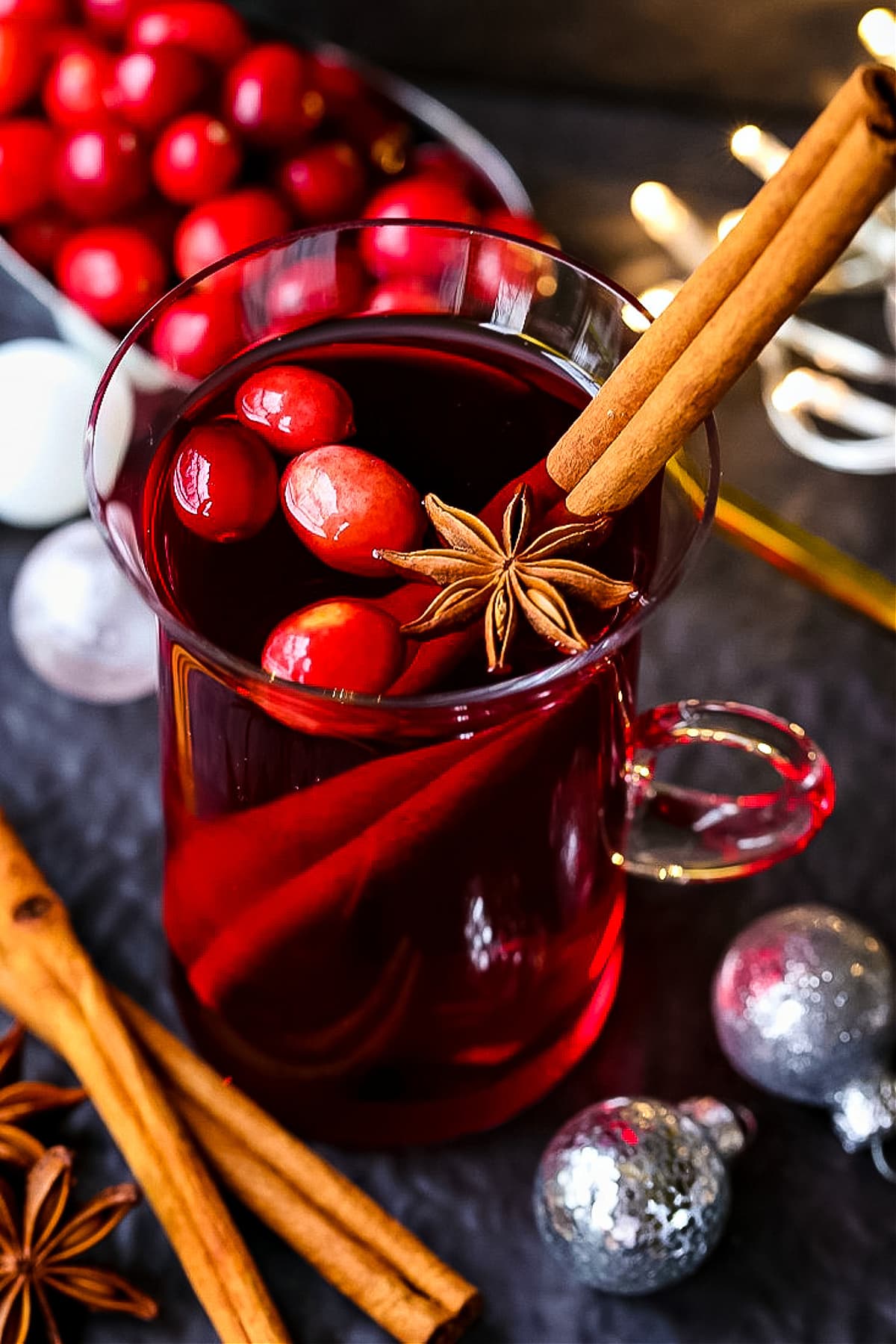 red punch in glass mug with cranberries and cinnamon stick