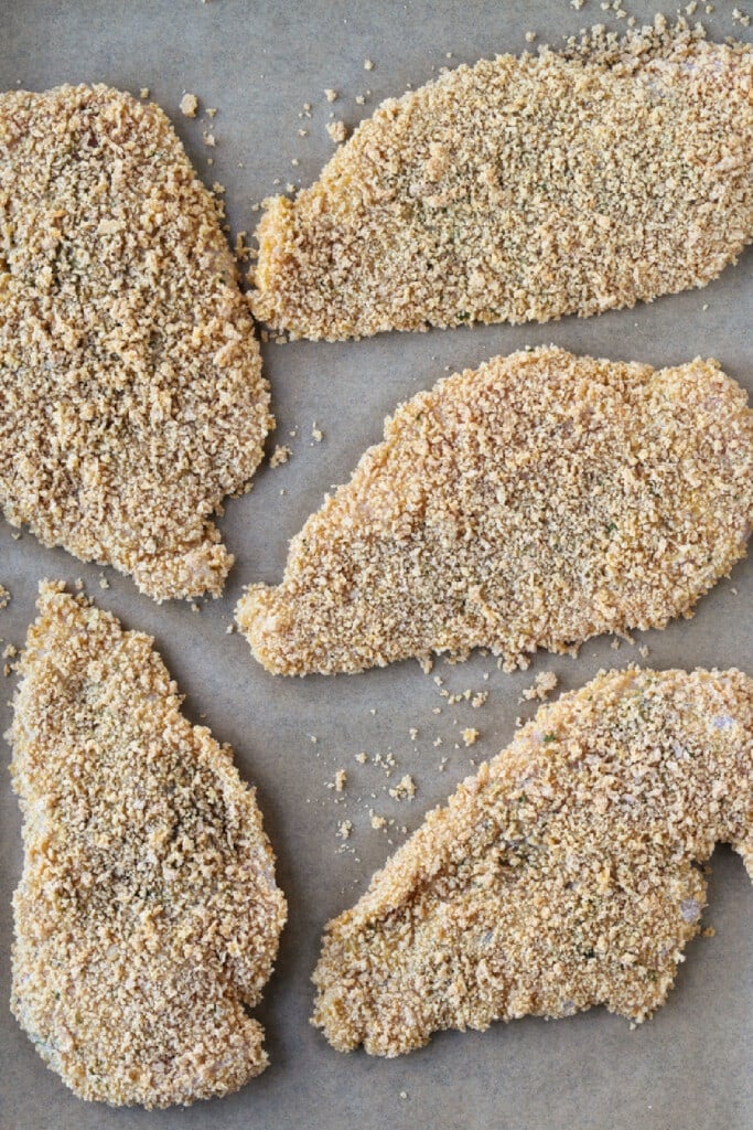 Air Fryer Chicken Katsu tastes as good as the fried version! Slice and drizzle with Asian BBQ sauce (Tonkatsu) and serve on a bed of rice. breaded chicken cutlets on parchment