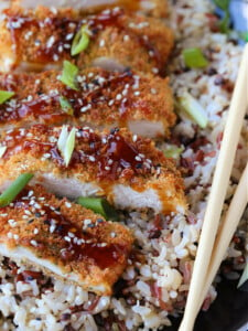 chicken katsu on a plate with rice and chop sticks