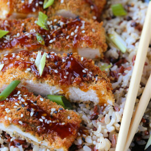 chicken katsu on a plate with rice and chop sticks