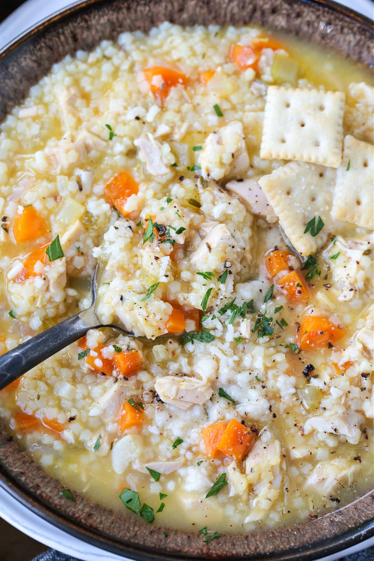 chicken pastina soup in a bowl with spoon