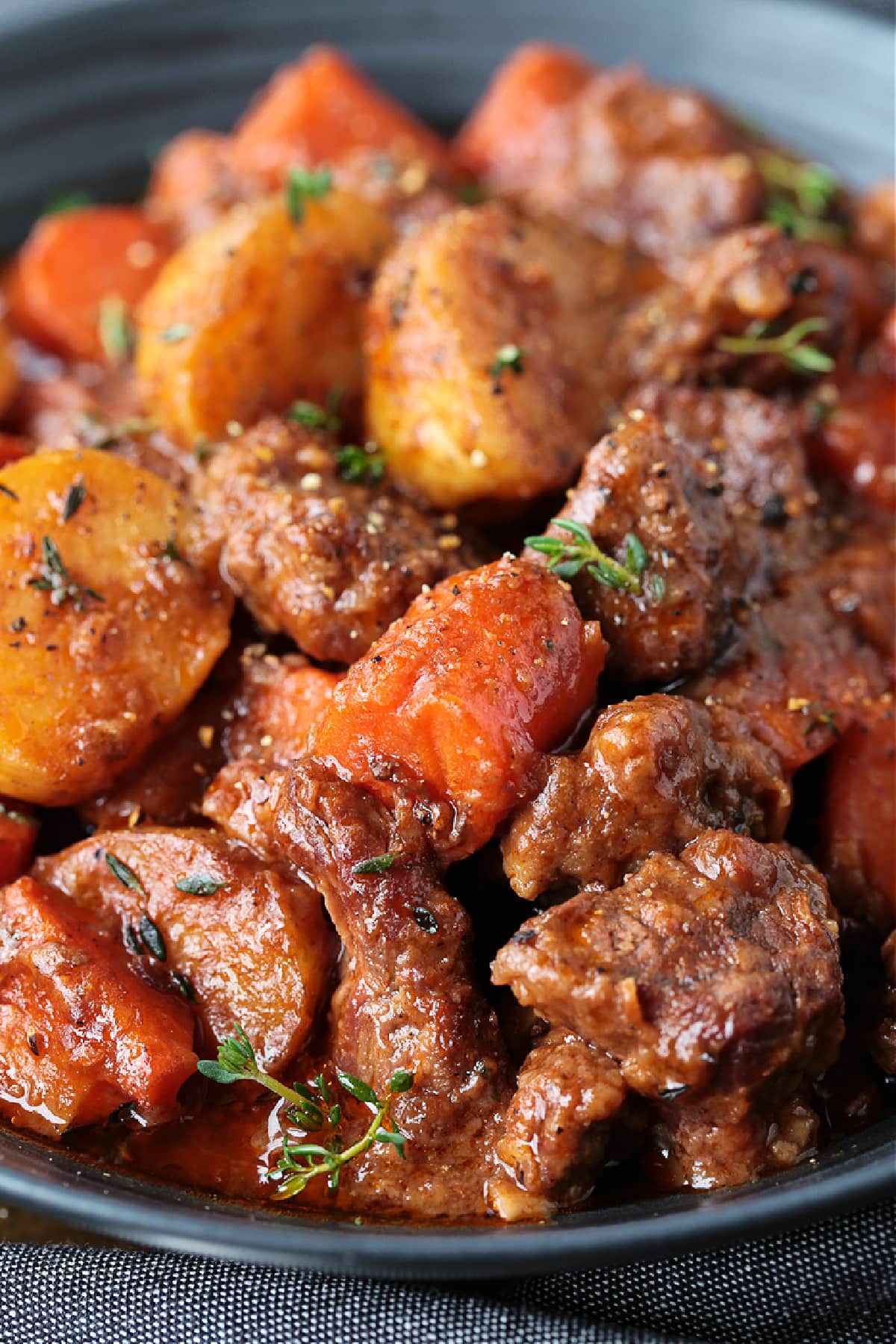 close up of beef stew on a black plate