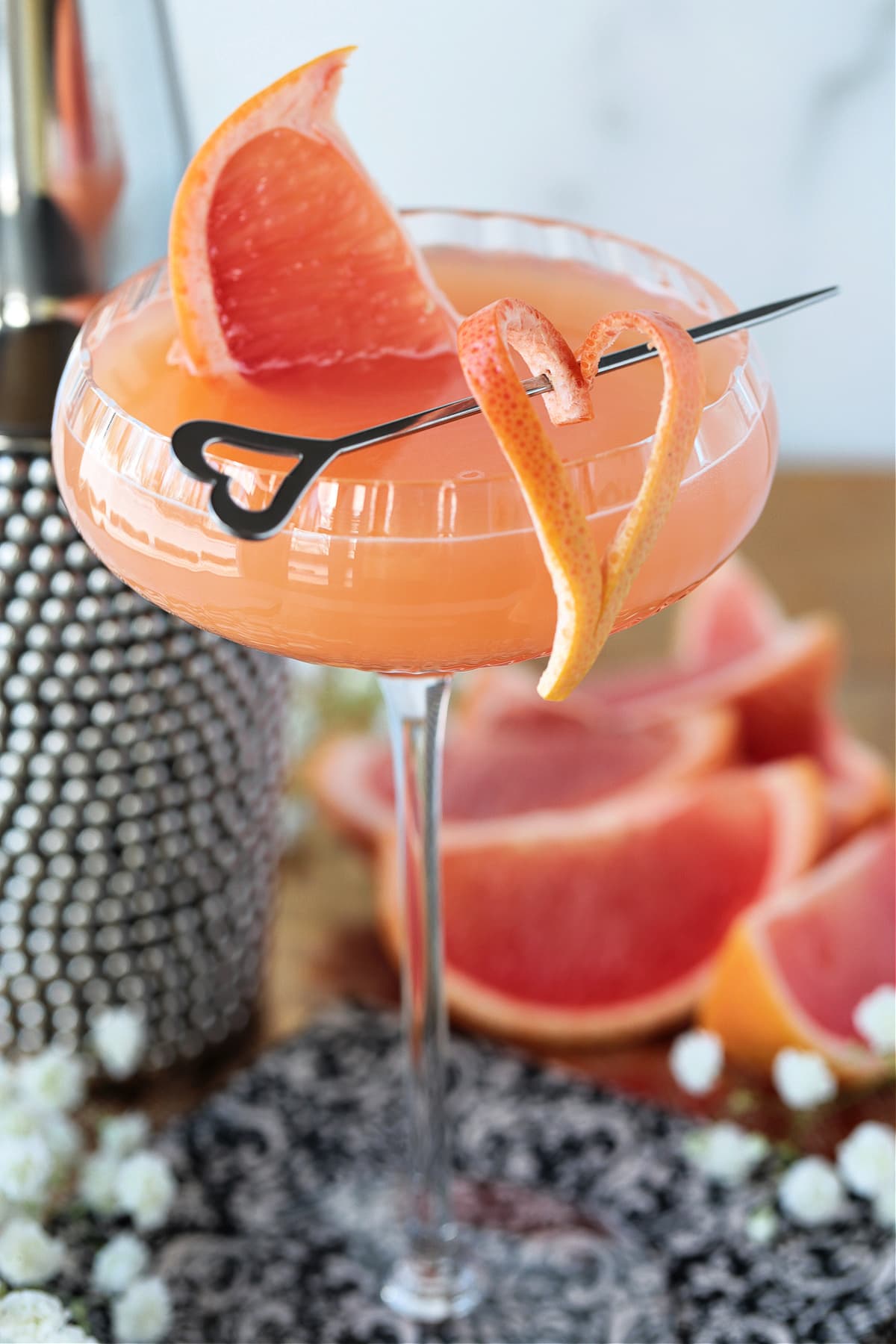 french blonde cocktail in a coup glass with fresh grapefruit garnish