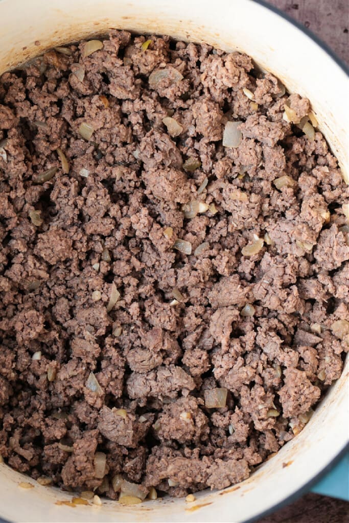 Our Ground Beef Chili recipe is loved by all! Not too spicy with big, bold flavors. Make a big batch for the week, leftovers are even better! cooked ground beef in a pot for making chili