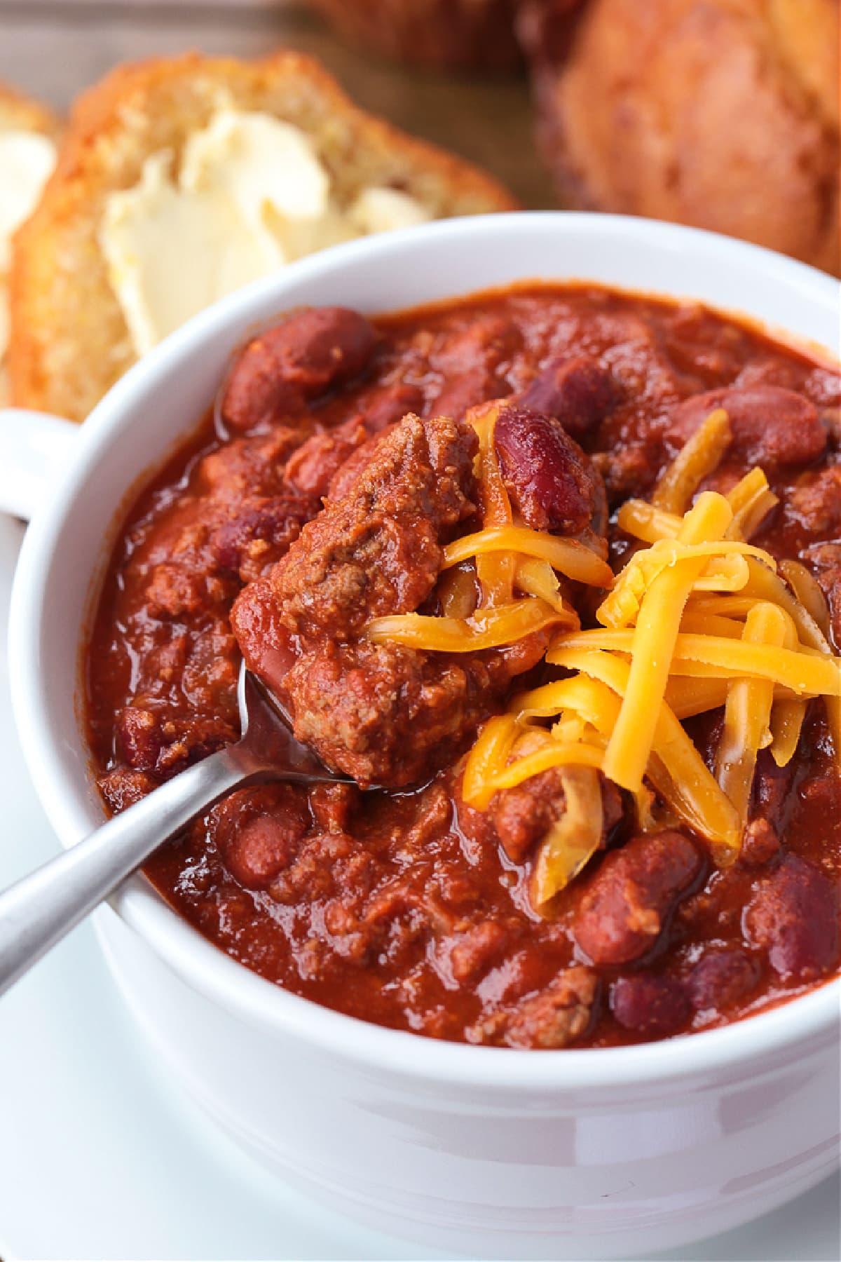 beef chili in white bowl with spoon