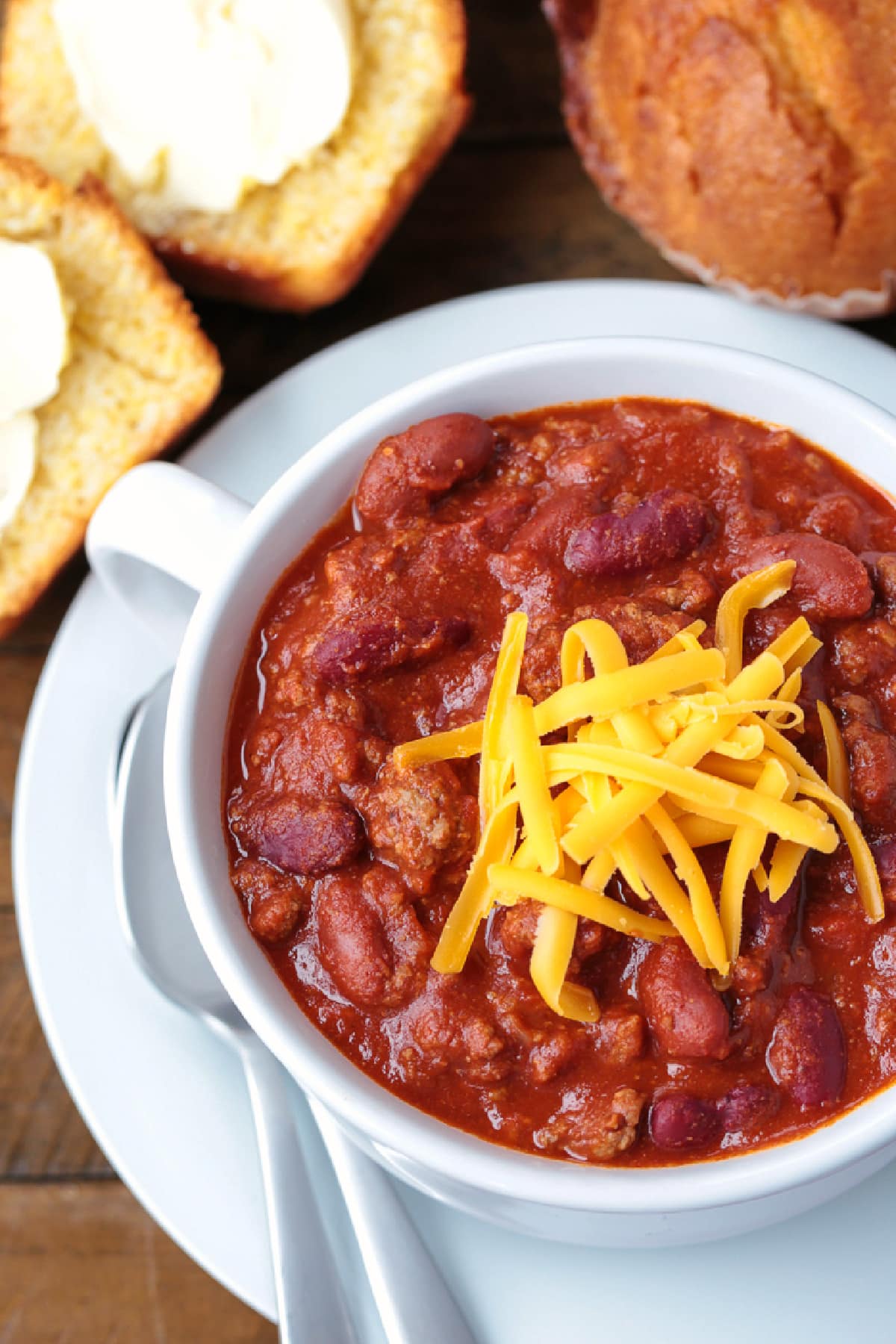 Our Ground Beef Chili recipe is loved by all! Not too spicy with big, bold flavors. Make a big batch for the week, leftovers are even better! chili in a bowl with shredded cheese on top