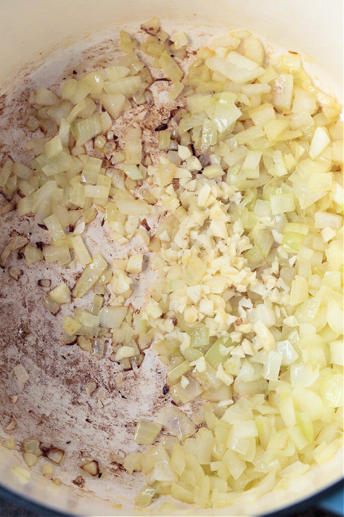 Our Ground Beef Chili recipe is loved by all! Not too spicy with big, bold flavors. Make a big batch for the week, leftovers are even better! onions and garlic in a pot for making chili