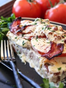 kentucky hot brown sandwich on black plate with forks