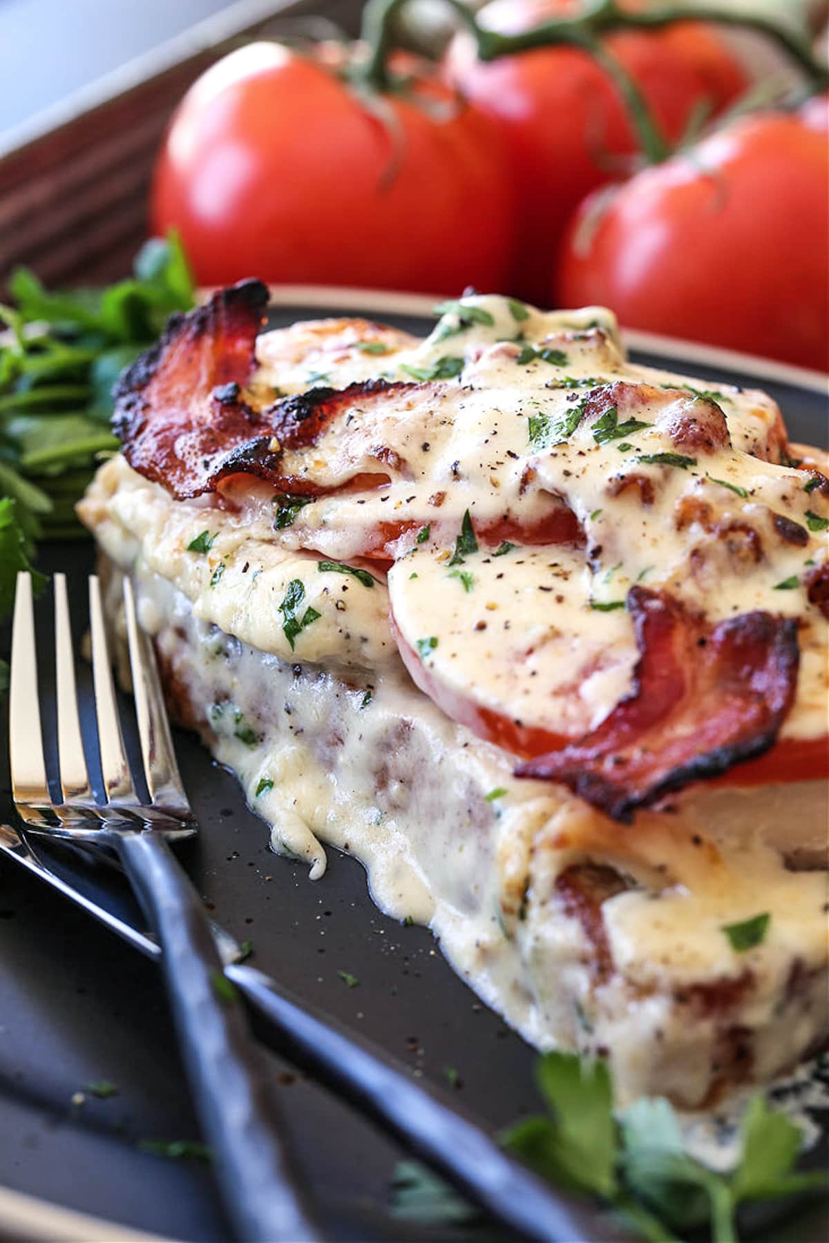 kentucky hot brown sandwich on black plate with forks