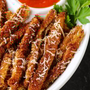 eggplant fries in a bowl with parmesan cheese and sauce