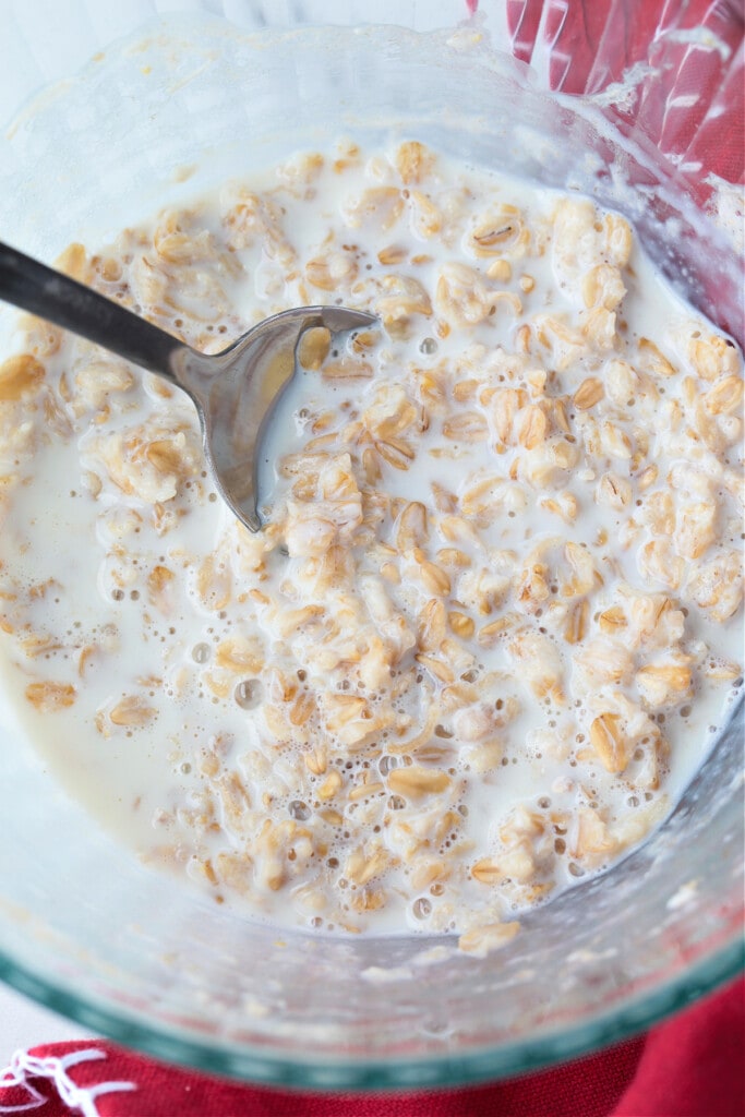 cooked oats in clear bowl with spoon