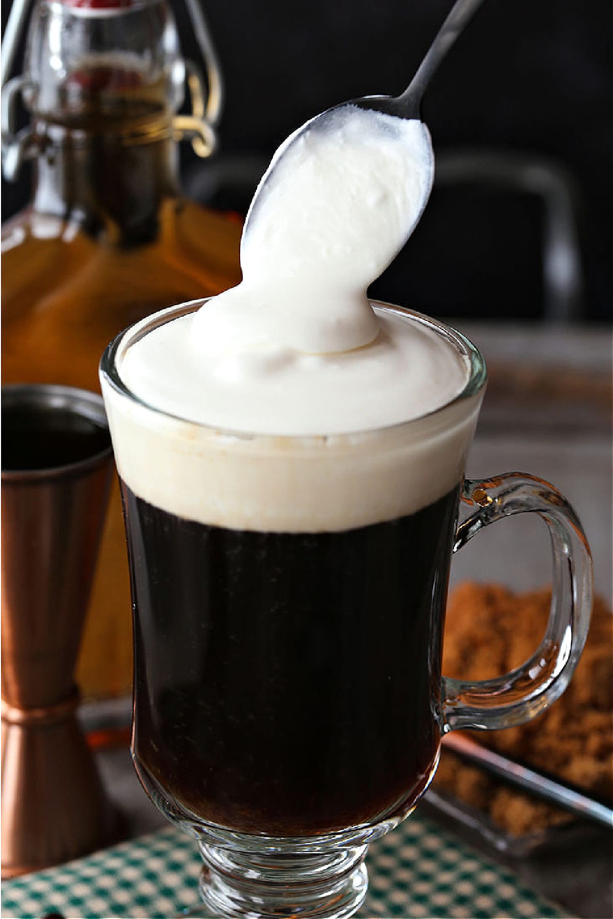 This classic Irish Coffee recipe can be served for an after dinner drink or for brunch. Slightly sweetened coffee with splash of whiskey! whipped cream being spooned on top of Irish coffee