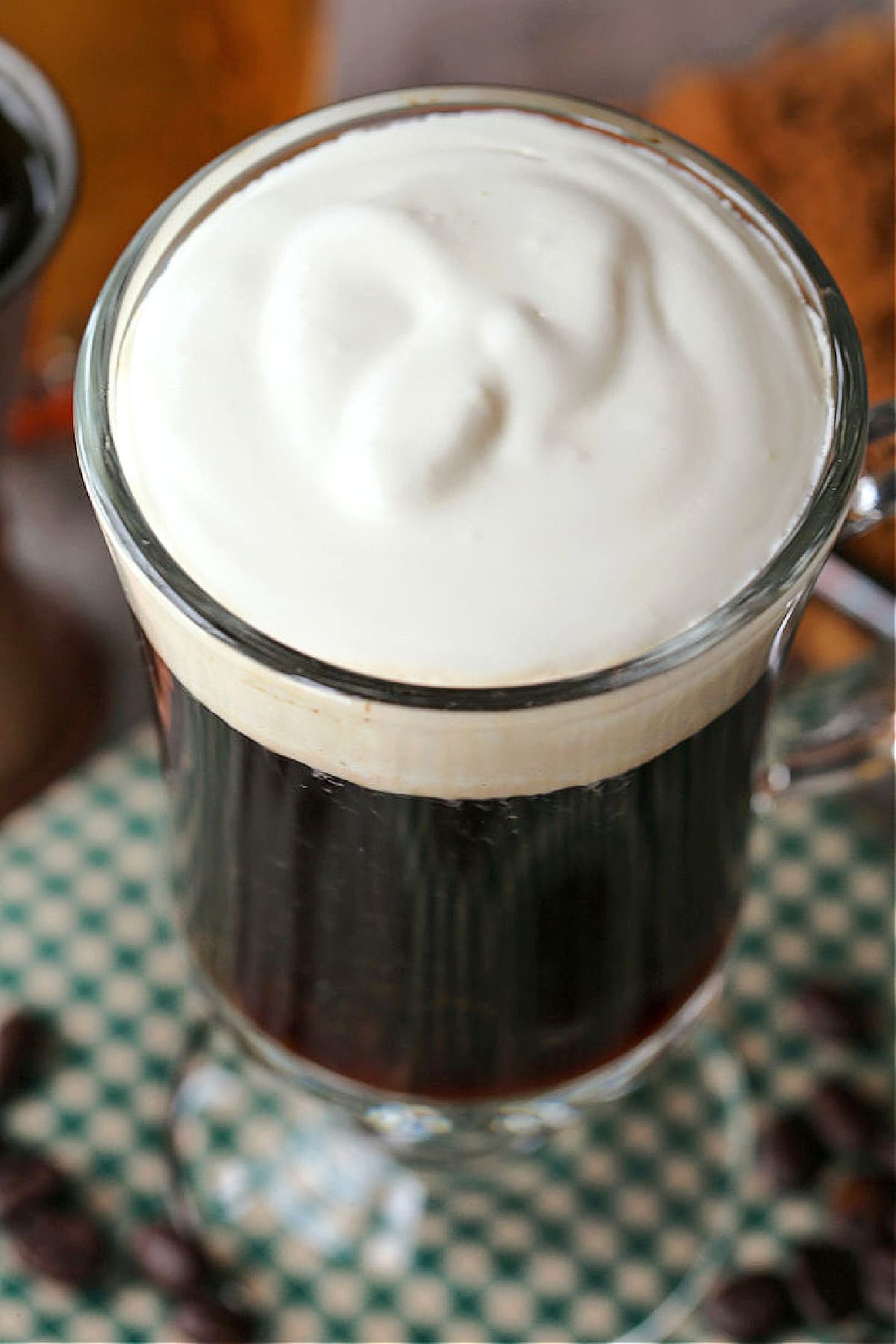 This classic Irish Coffee recipe can be served for an after dinner drink or for brunch. Slightly sweetened coffee with splash of whiskey! top shot of irish coffee in glass mug