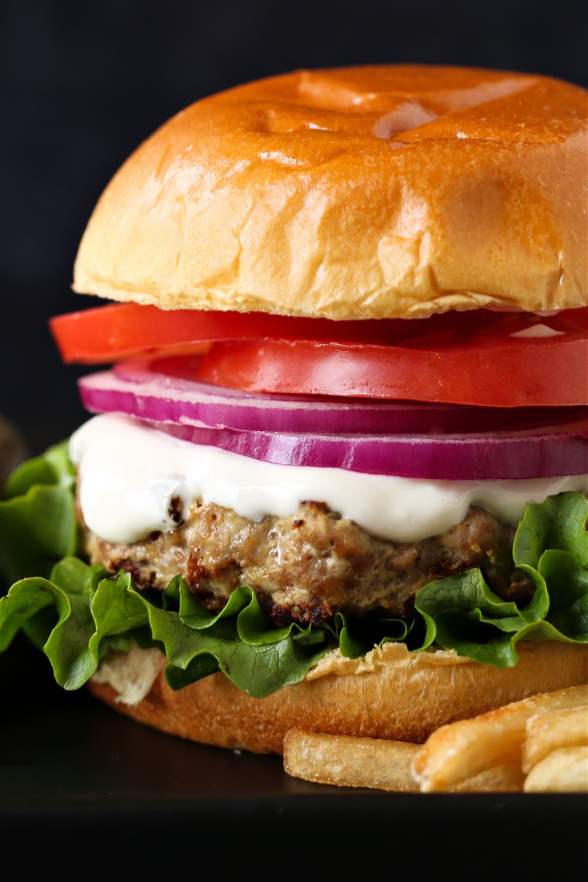 turkey burger on brioche bun with onion, tomato and mayonnaise