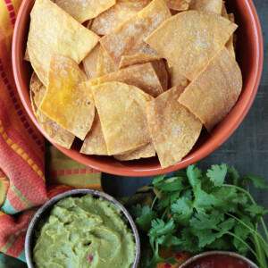 tortilla chips in large bowl with salsa and guacamole