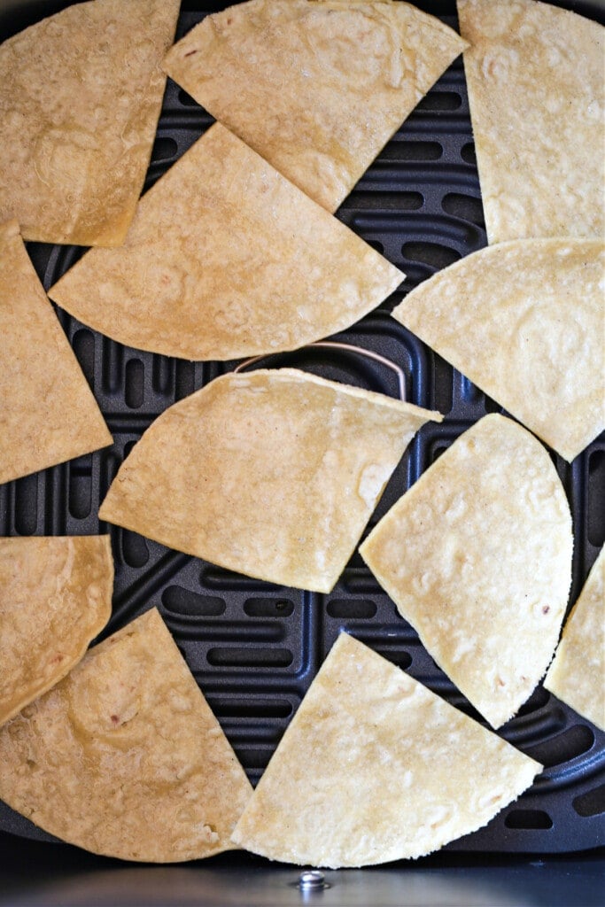 These Air Fryer Tortilla Chips are super crispy and so addicting! Dip them in salsa, serve them with soups or make a platter of nachos! tortilla chip wedges in air fryer