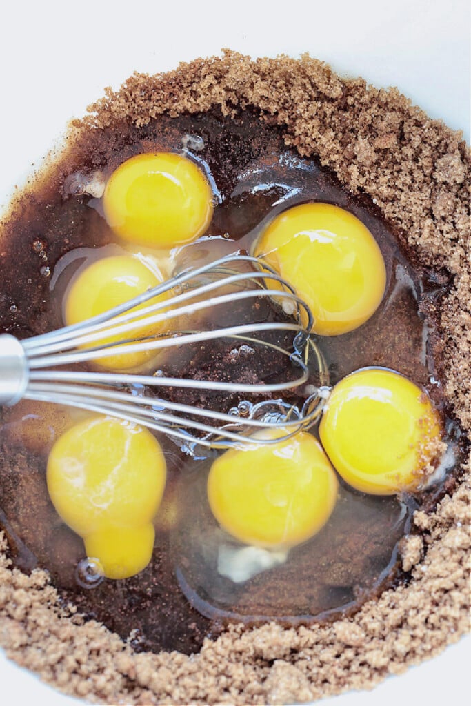 eggs in bowl with brown sugar and whisk