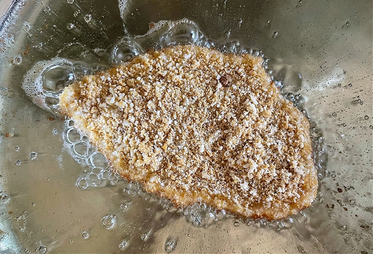 Sesame Chicken Milanese is a delicious twist on the classic chicken recipe! Thin, crispy chicken cutlets topped with crisp greens and an Asian vinaigrette! breaded chicken cutlet in oil