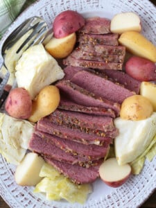 corned beef, cabbage and potatoes sliced on a white platter