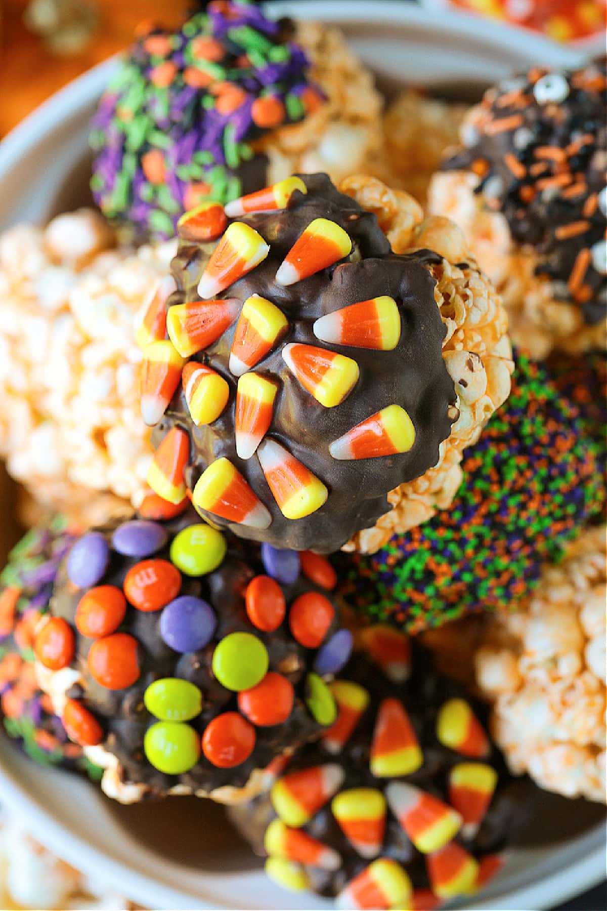 Halloween Popcorn Balls are a tasty and festive homemade treat for Halloween! Perfect for trick-or-treaters or for a Halloween party favor! homemade popcorn balls decorated with candy corn