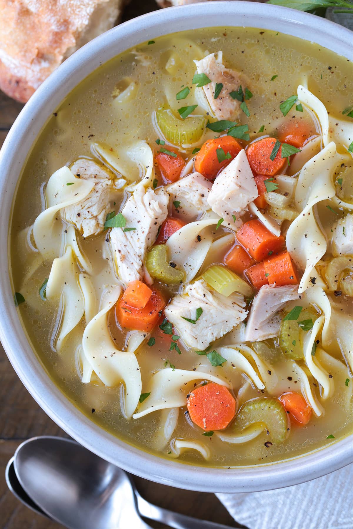 The best Homemade Turkey Soup is made with leftover turkey bones! Cozy and comforting, it's the best bowl of turkey soup you'll ever taste! close up of bowl of turkey soup