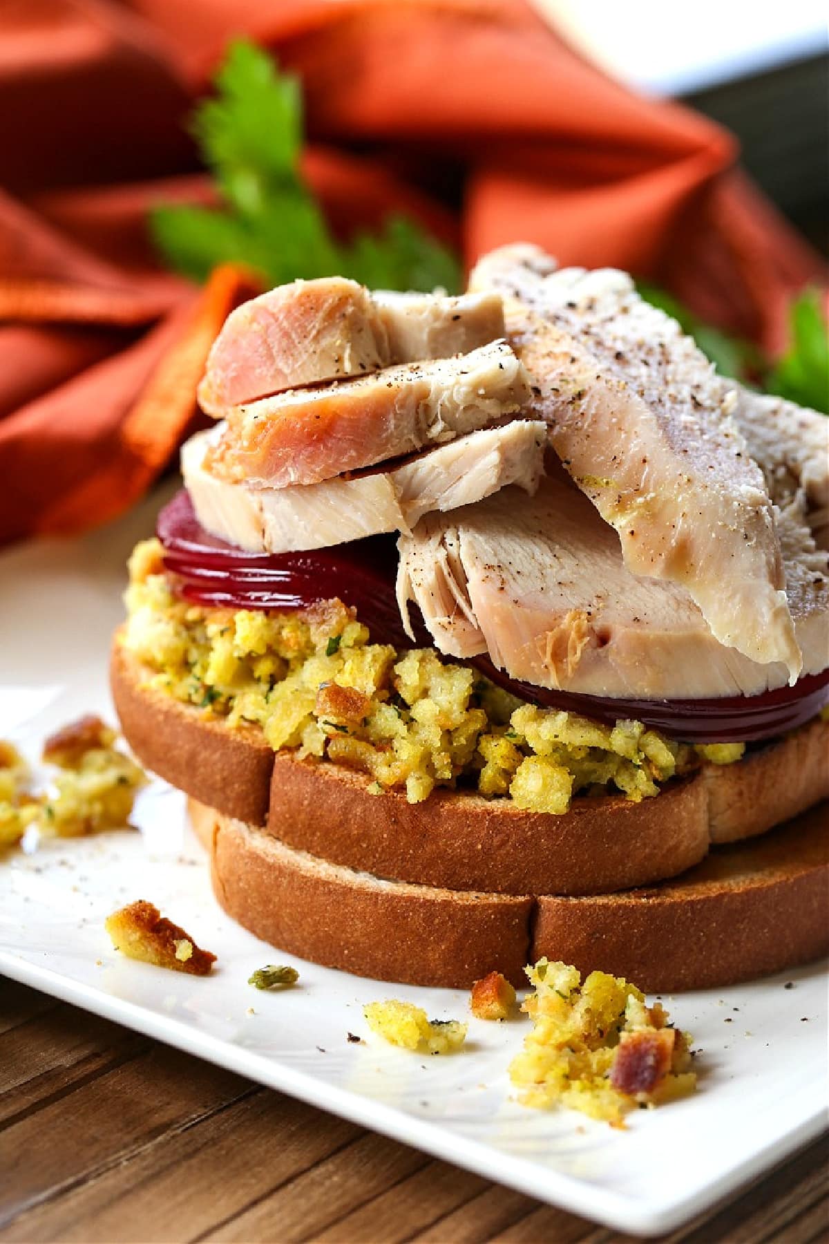 Make a Hot Turkey Sandwich with your leftover turkey! This tasty, open faced sandwich is our favorite way to use up Thanksgiving leftovers! sliced turkey over stuffing and cranberry sauce for sandwich recipe