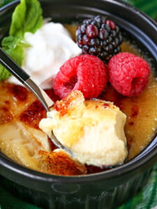 spoonful of creme brulee with berries and whipped cream