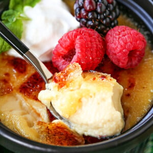 spoonful of creme brulee with berries and whipped cream