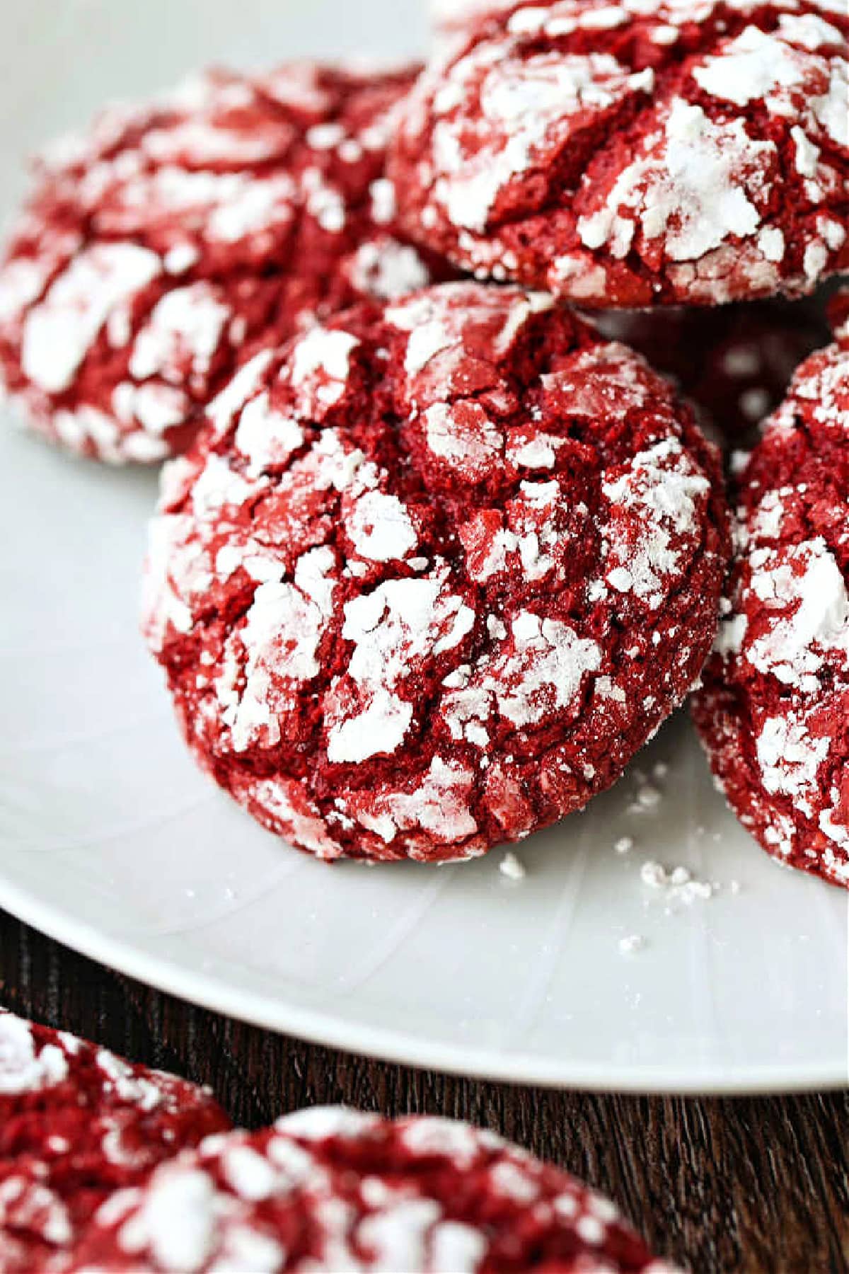 These Red Velvet Crinkle Cookies start off with your favorite boxed cake mix! Soft, cake-like cookies that are perfect for all occasions! red velvet crinkle cookies on white plate
