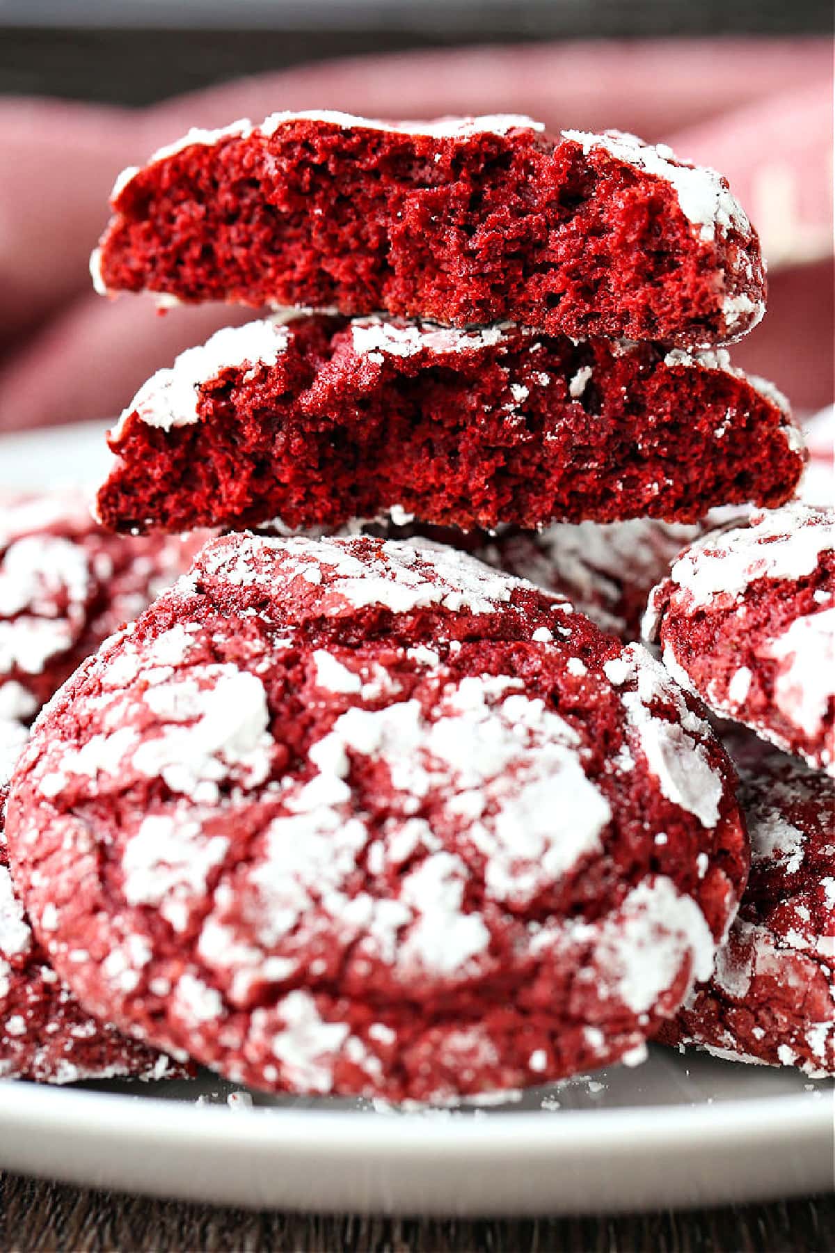 red velvet crinkle cookies stacked and broken in half