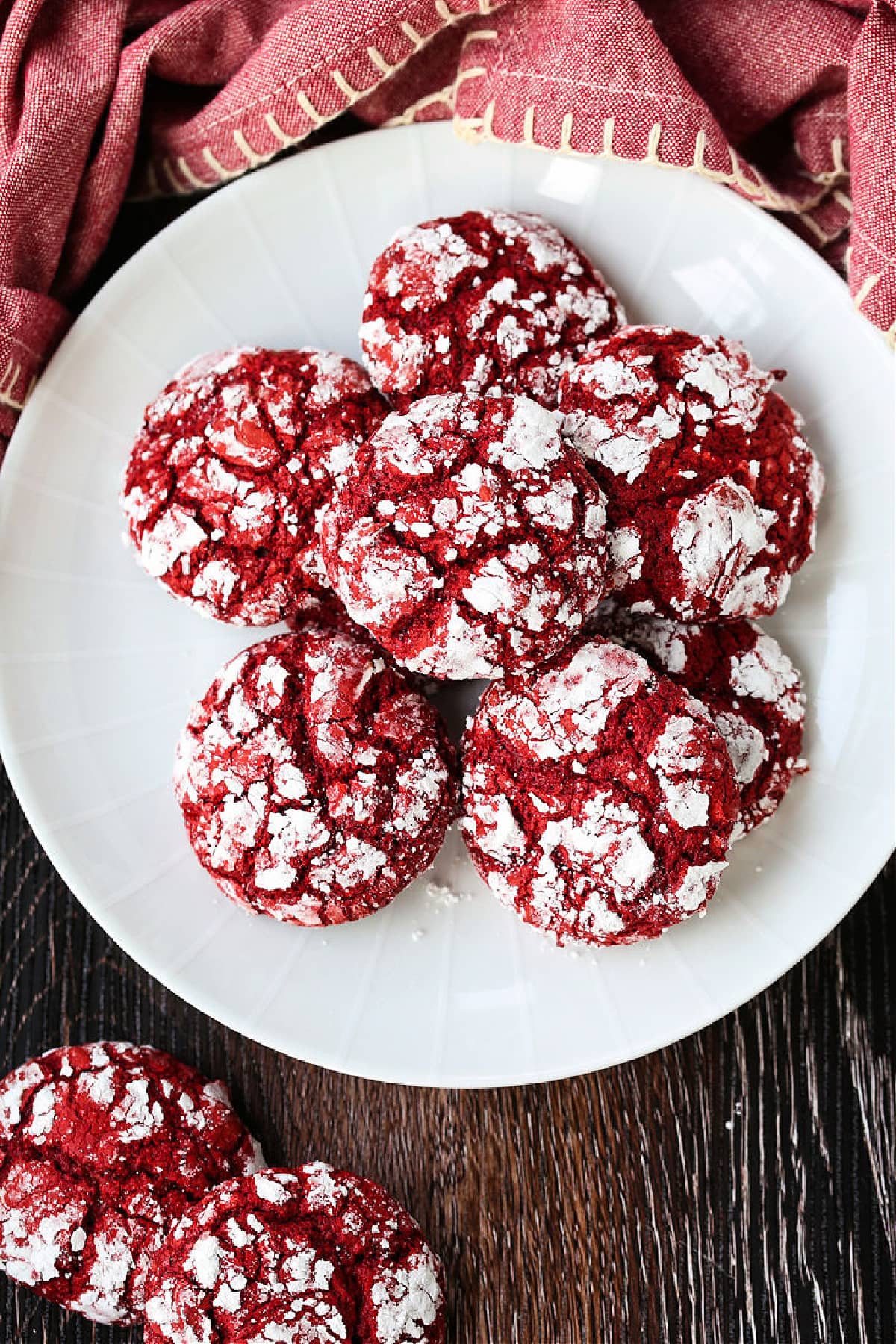 These Red Velvet Crinkle Cookies start off with your favorite boxed cake mix! Soft, cake-like cookies that are perfect for all occasions! red velvet crinkle cookies on white plate with napkin