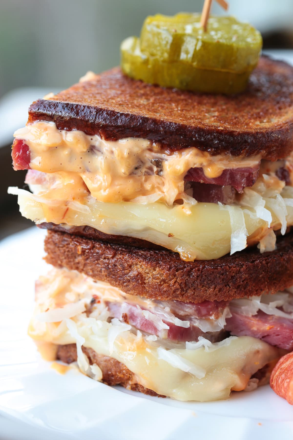 grilled reuben sandwich stacked in plate