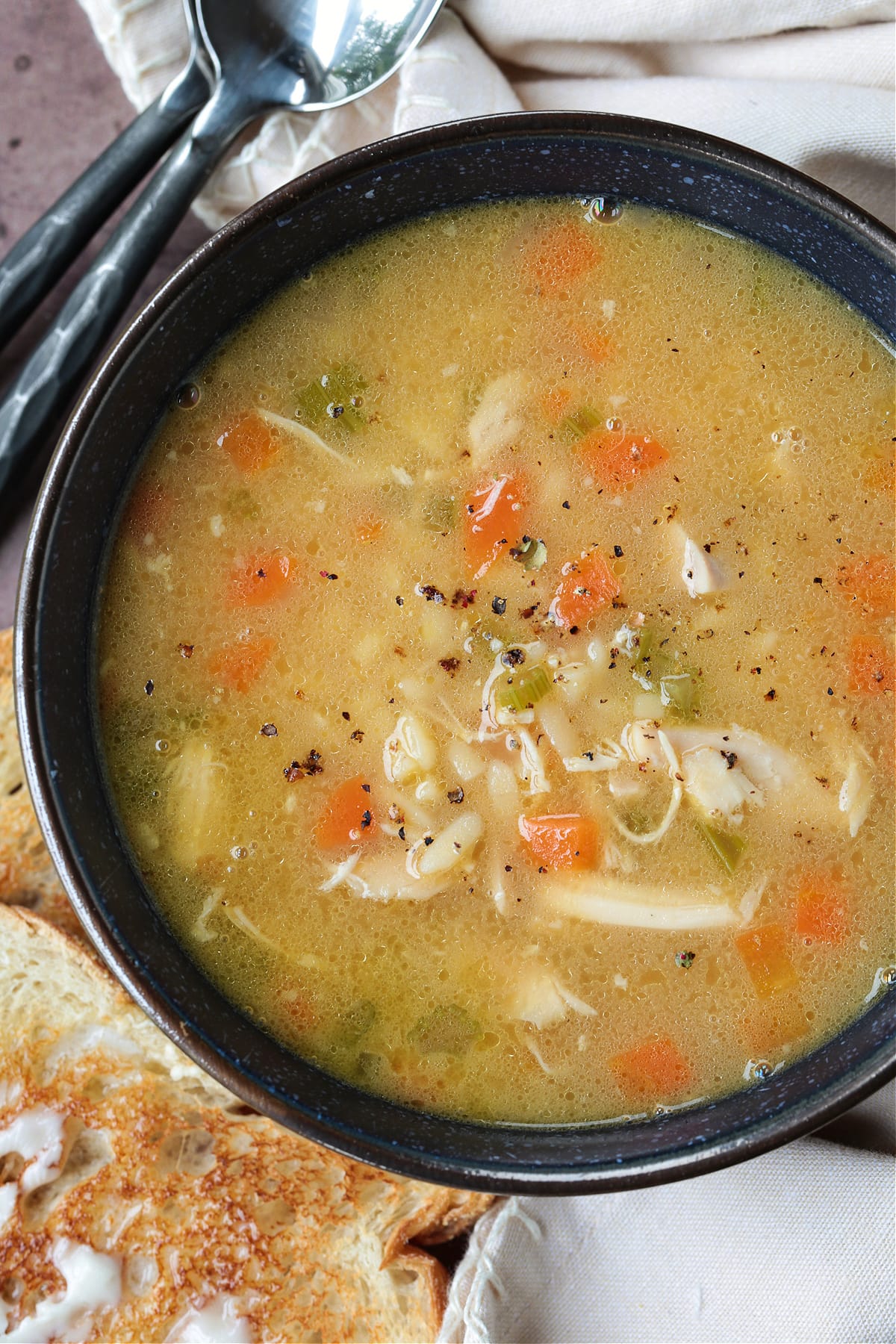 Rotisserie Chicken Stock is so easy to make with leftover rotisserie chicken bones! Use this hearty chicken stock in soups, stews and more! rotisserie chicken stock made into soup in black bowl