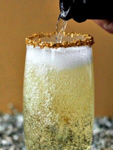 glass of champagne with champagne pouring into it