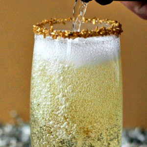 glass of champagne with champagne pouring into it