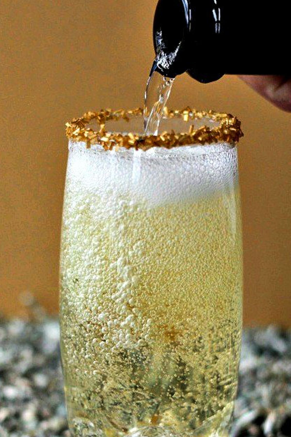 glass of champagne with champagne pouring into it