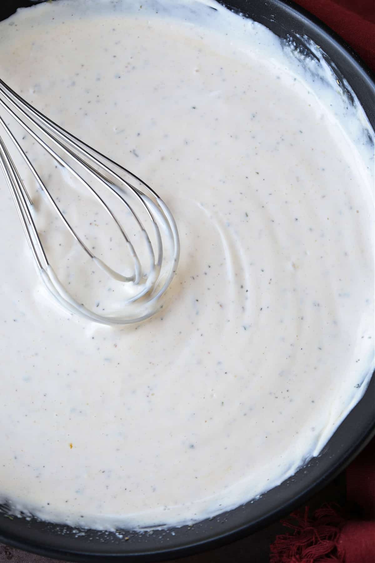 Ranch Potato Salad is a delicious, make ahead side dish! A hearty and tangy potato salad with creamy red potatoes and thick, crisp bacon. mayonnaise dressing for potato salad in bowl with whisk