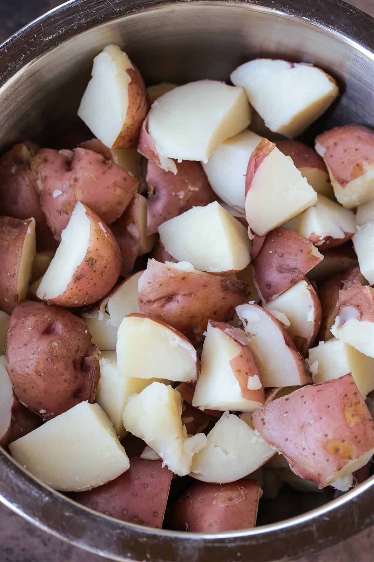 Ranch Potato Salad is a delicious, make ahead side dish! A hearty and tangy potato salad with creamy red potatoes and thick, crisp bacon. cooked red potatoes in a pot