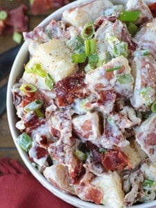 ranch potato salad in white bowl with napkin