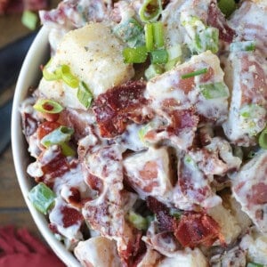 ranch potato salad in white bowl with napkin