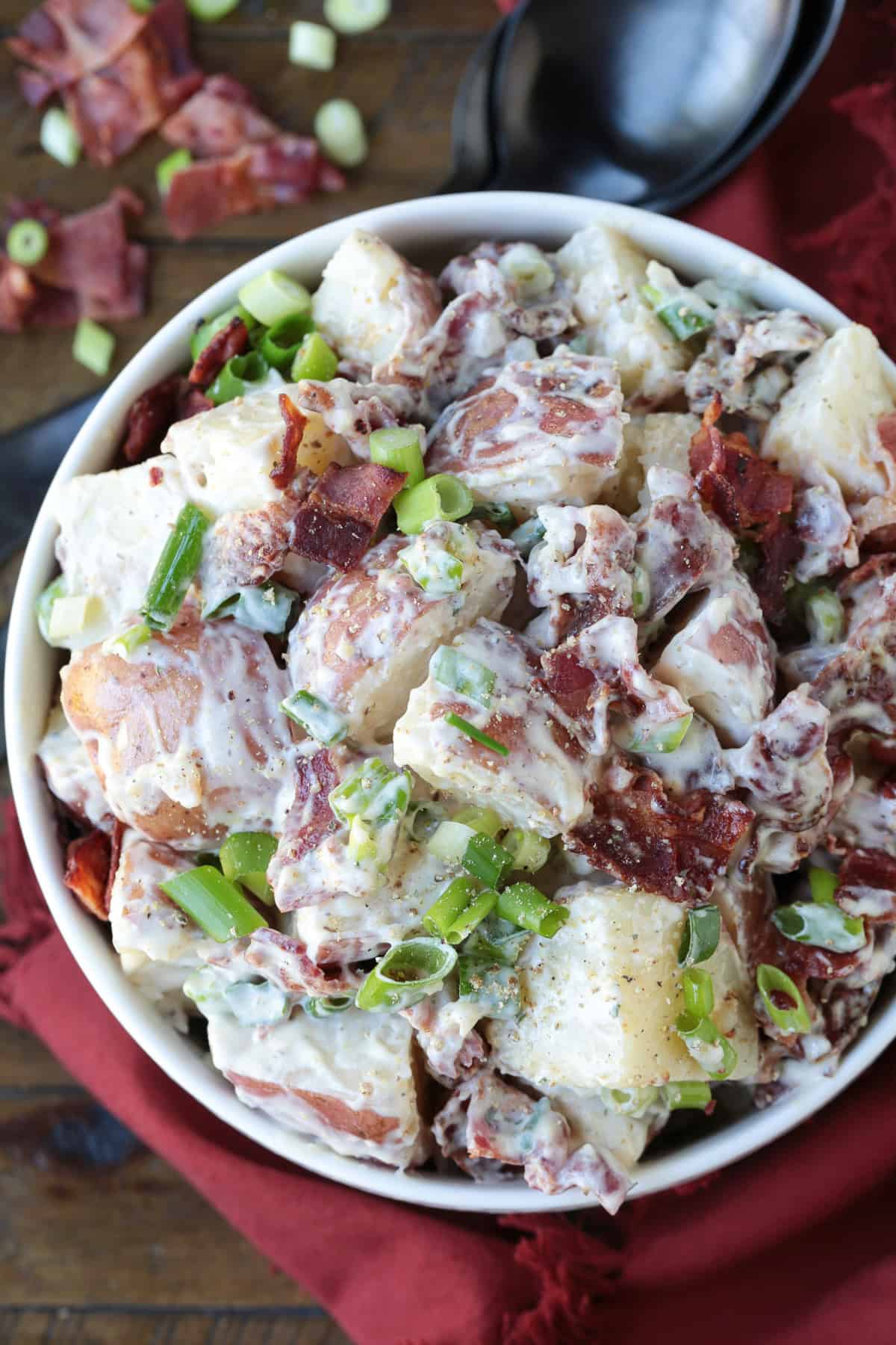 Ranch Potato Salad is a delicious, make ahead side dish! A hearty and tangy potato salad with creamy red potatoes and thick, crisp bacon. potato salad with bacon and scallions in white bowl