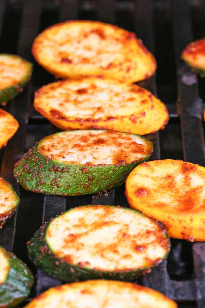 Grilled Zucchini and Squash is an easy side dish for any meal! Seasoned with our all purpose spice blend and grilled to perfection! seasoned slices of zucchini and squash on grill