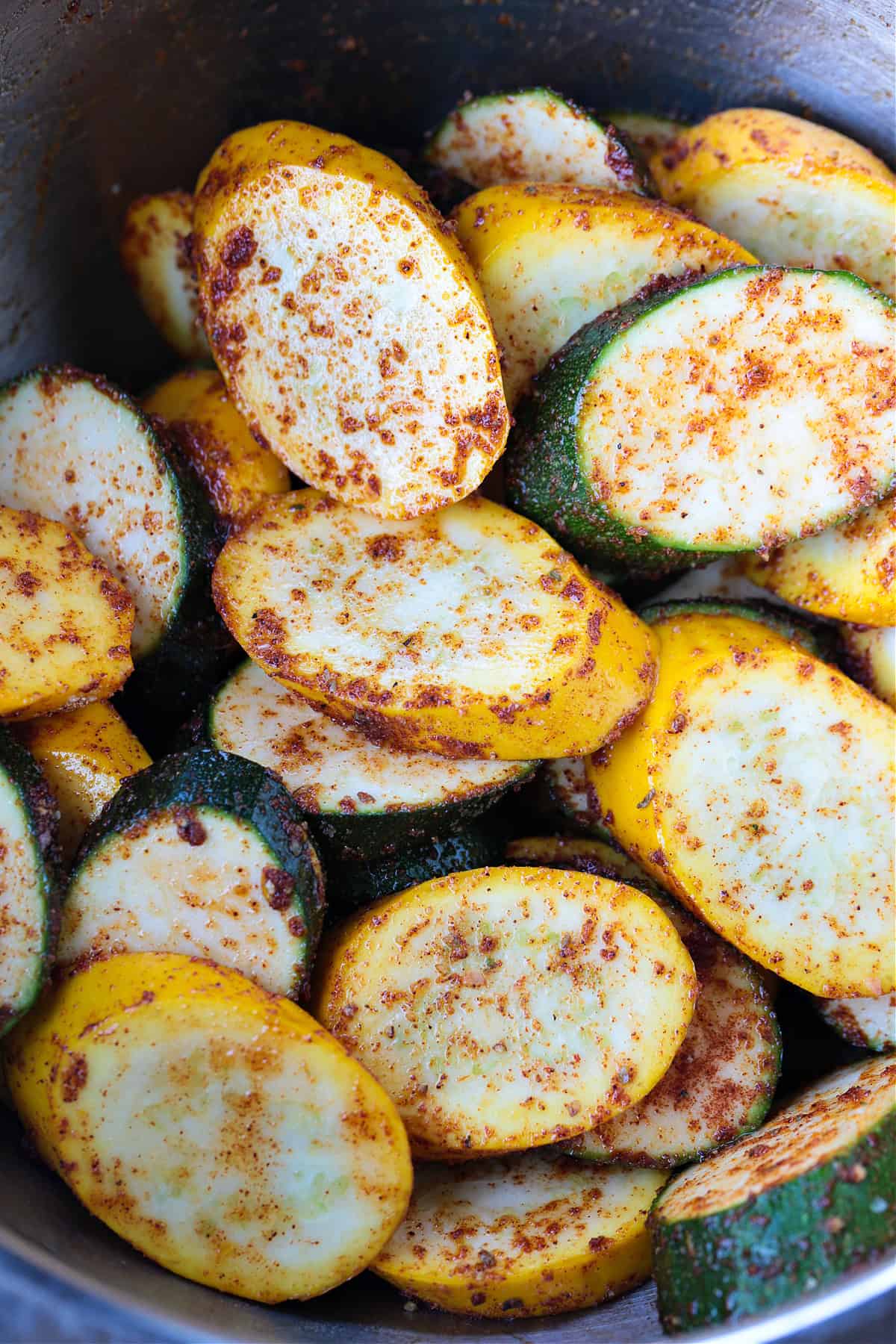 Grilled Zucchini and Squash is an easy side dish for any meal! Seasoned with our all purpose spice blend and grilled to perfection! thick slices of zucchini and squash tossed with seasoning in bowl